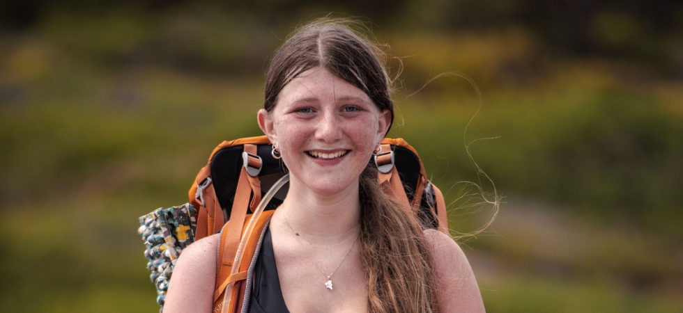 Hiking woman looking and smiling at camera